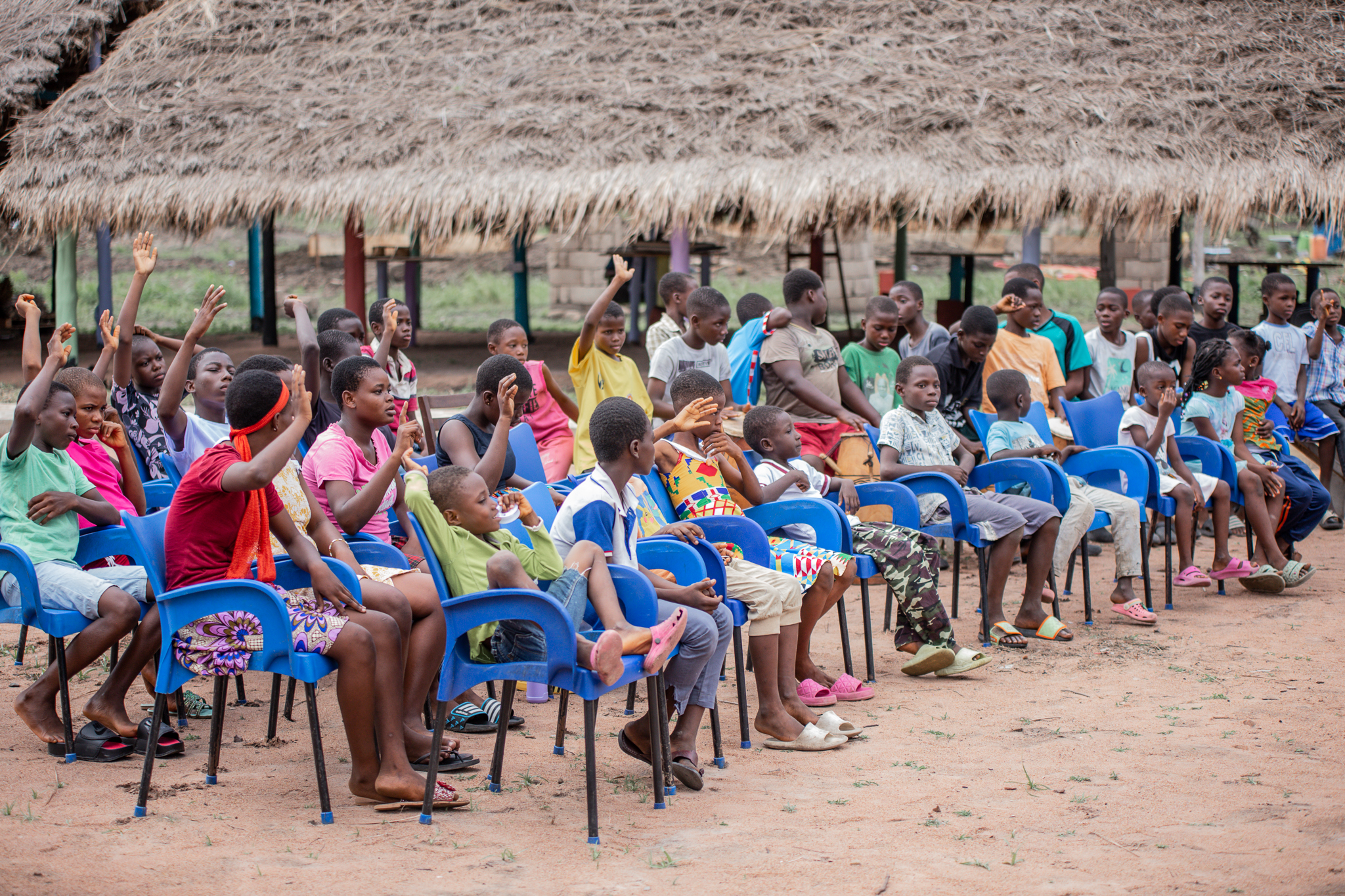 Children with books smiling outdoors